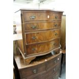 A reproduction mahogany serpentine fronted four drawer chest.