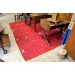 A modern red ground carpet with stylized motifs 10ft x 7ft.