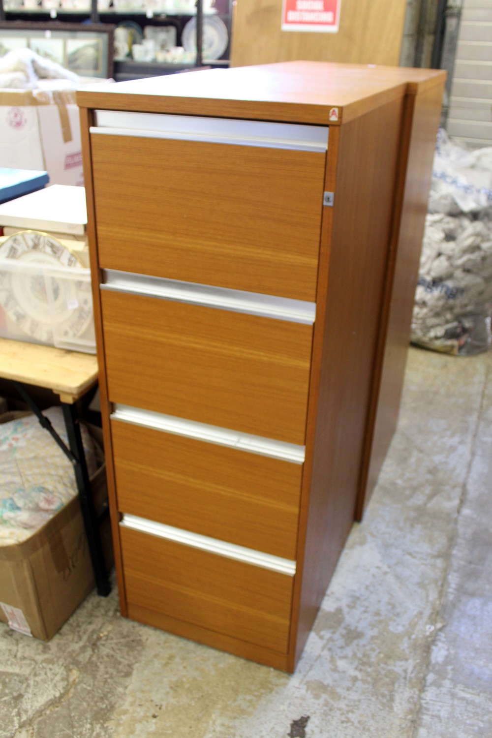 A modern four drawer filing cabinet with key.