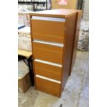 A modern four drawer filing cabinet with key.