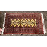 A 20th century Bokhara style rug, with yellow ground central panel and six lozenge shaped motifs.