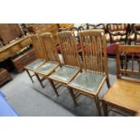 A set of four oak high back dining chairs.