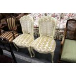 A pair of French style upholstered side chairs with painted frames.