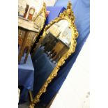 A large decorative gilt framed mirror 6ft 2ins high x 4ft 4ins wide.