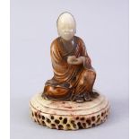 A GOOD CHINESE CARVED SOAPSTONE FIGURE OF ROHAN, in a seated position holding a vessel, with a