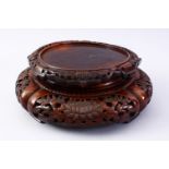 A GOOD 19TH CENTURY CHINESE CARVED HARD WOOD STAND, carved with sceens of flora, 32cm diameter ,