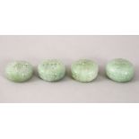 FOUR 19TH / 20TH CENTURY CHINESE CARVED CELADON JADE PENDANTS, all of cylindrical form and pierced,