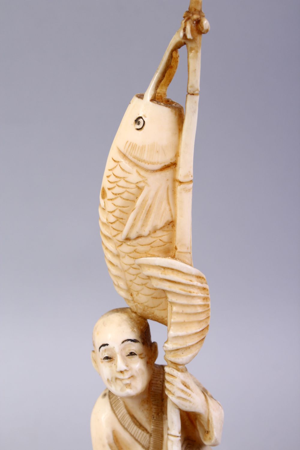 A JAPANESE MEIJI PERIOD CARVED IVORY OKIMONO - FISHERMAN, The man stood holding his rod and catch, - Image 7 of 9