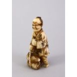 A SMALL JAPANESE MEIJI PERIOD CARVED IVORY NETSUKE - the figure carved holding tied sacks of