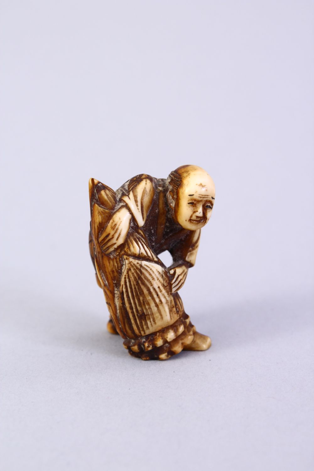 A JAPANESE MEIJI PERIOD CARVED IVORY NETSUKE, the figure holding a tied parcel, signed to side, 3. - Image 2 of 6