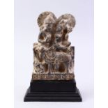A GOOD GHANDARA CARVED STONE FIGURE, of two figures with an animal, 22cm high on stand.