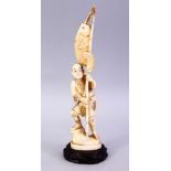 A JAPANESE MEIJI PERIOD CARVED IVORY OKIMONO - FISHERMAN, The man stood holding his rod and catch,