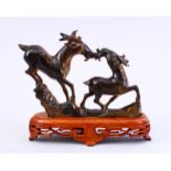 A GOOD CHINESE CARVED TIGERS EYE FIGURE OF TWO DEER, on a hardwood fitted base, 15.5cm high