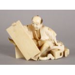 A GOOD JAPANESE MEIJI PERIOD CARVED IVORY OKIMONO OF A WOOD WORKER, the worker seated upon a bench