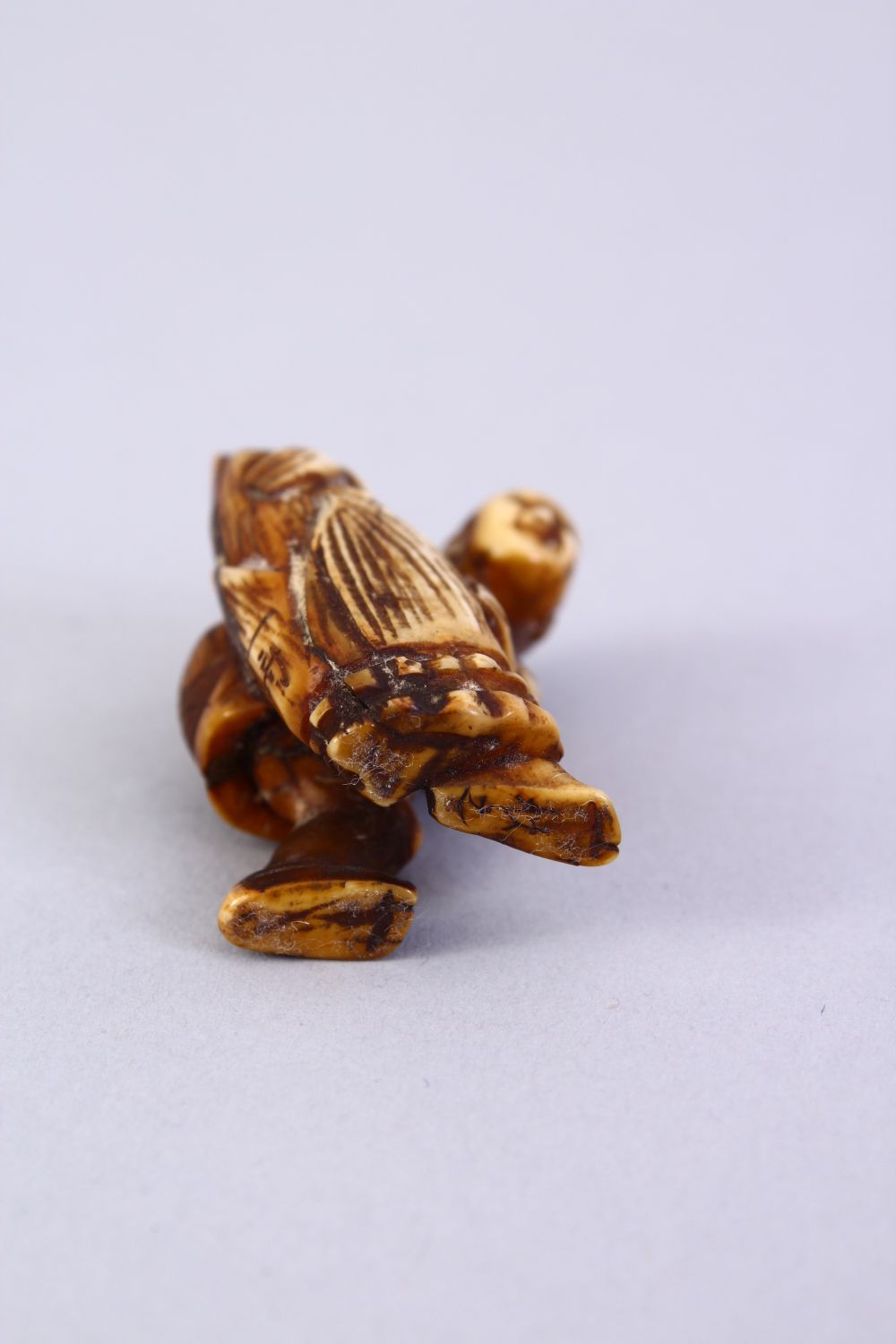 A JAPANESE MEIJI PERIOD CARVED IVORY NETSUKE, the figure holding a tied parcel, signed to side, 3. - Image 6 of 6