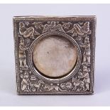 A GOOD INDIAN SILVER PHOTO FRAME AND STAND, with embossed decoration depicting figures and