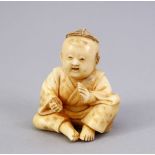 A JAPANESE MEIJI PERIOD CARVED IVORY NETSUKE OF A BOY, the boy in a seated position clapping his