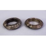 TWO ISLAMIC WHITE METAL POSS SILVER BANGLES, the untested white metal with embossed decoration, 11.