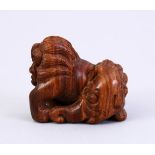 A JAPANESE MEIJI PERIOD STYLE CARVED WOODEN NETSUKE OF A LION ELEPHANT, the lion dog with an