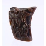A CHINESE CARVED HORN LIBATION CUP, carved with figures in landscapes, 6cm.