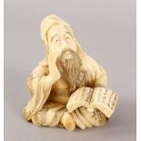 A JAPANESE MEIJI PERIOD CARVED IVORY OKIMONO OF A PRIEST, in a seated position holding his book of