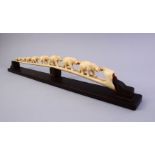 A JAPANESE MEIJI PERIOD CARVED IVORY ELEPHANT BRIDGE GROUP, carved in one piece to depict a herd
