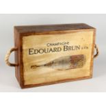 A NOVELTY WOODEN BOX, decorated with a champagne bottle. 21,5ins wide.