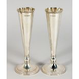 A PAIR OF FLUTED SILVER VASES, with circular bases. 6.5ins high. Birmingham 1903.