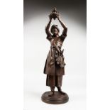 A 19TH CENTURY BRONZE FIGURE OF A TURKISH MAN holding aloft a vessel, on a circular base. 23ins