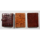 THREE CROCODILE AND SNAKESKIN WALLETS/NOTEBOOKS. 5ins wide.