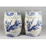 A PAIR OF CHINESE BLUE AND WHITE POTTERY BARREL SEATS. 12ins high.