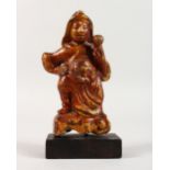 AN UNUSUAL GILDED AND LACQUERED CAST METAL ORIENTAL FIGURE, on a stand. 7.5ins high.