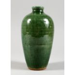 A CHINESE GREEN GLAZED POTTERY VASE. 7ins high.