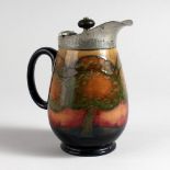 A SMALL MOORCROFT JUG, decorated in the Eventide landscape design, with a pewter hinged lid,
