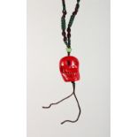 A CHINESE CORAL CARVED SKULL PENDANT. 1ins high.