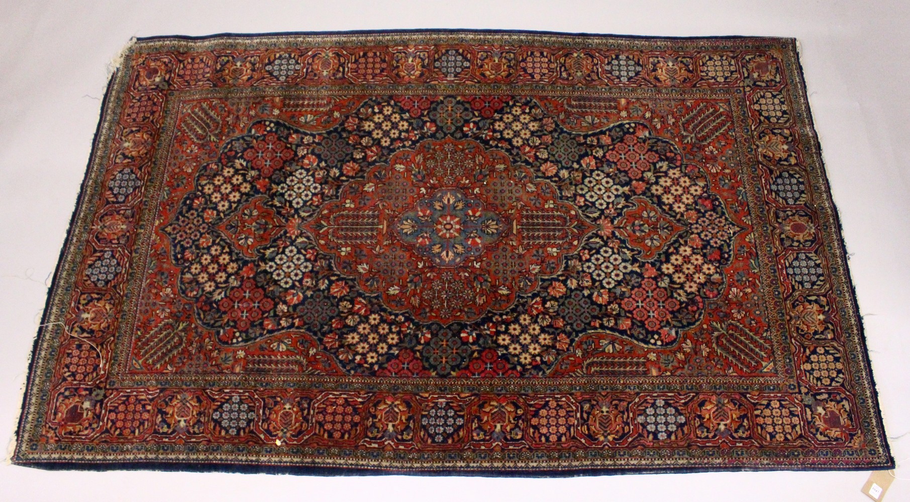 A KASHAN RUG, 20th Century dark blue ground with allover stylized tree and flower decoration. 6ft