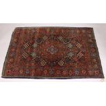 A KASHAN RUG, 20th Century dark blue ground with allover stylized tree and flower decoration. 6ft