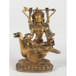 A CHINESE GILT BRONZE FIGURE OF A DEITY SEATED ON A BIRD, inset with semi-precious stones. 9.5ins
