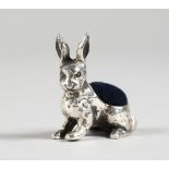 A SMALL NOVELTY SILVER RABBIT PIN CUSHION. 1ins long.