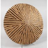 AN AFRICAN CIRCULAR WOOD SHIELD, with radically carved decoration. 23ins diameter.