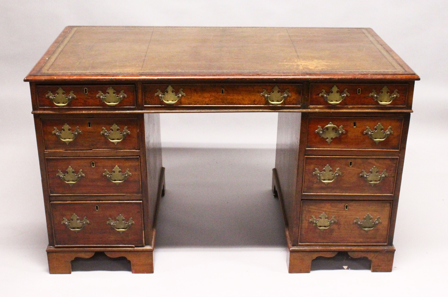 A GEORGE III MAHOGANY PEDESTAL DESK, with gilt tooled leather inset writing surface, three frieze