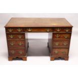 A GEORGE III MAHOGANY PEDESTAL DESK, with gilt tooled leather inset writing surface, three frieze