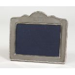 A SILVER PHOTOGRAPH FRAME, with serpentine top. 5.25ins x 6ins.