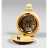 A CARVED BONE WATCH SHAPED COMPASS, engraved with a sailing ship.