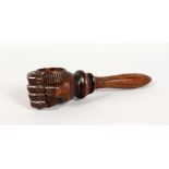 A CARVED WOOD NUTCRACKER, modelled as a clenched fist. 8.5ins long.