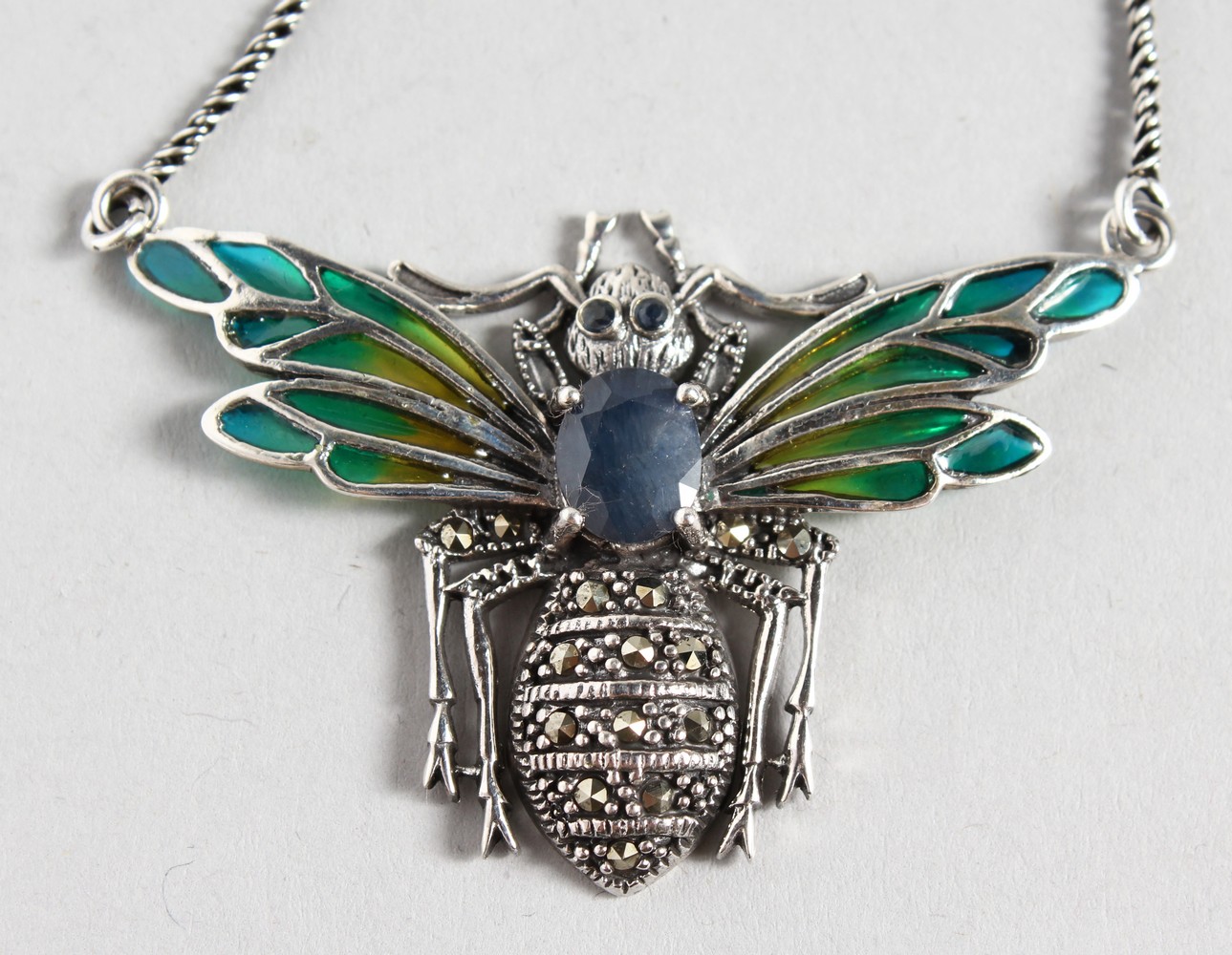 A SILVER SAPPHIRE SET "BEE" PENDANT AND CHAIN.