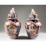 A PAIR OF JAPANESE IMARI VASES AND COVERS. 12ins high.