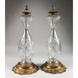 A GOOD PAIR OF CUT GLASS STANDARD LAMPS, with gilt metal bases.
