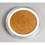 A CHINESE GILT METAL COIN, cased. 1.5ins diameter.