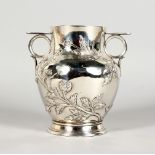 A SILVER BALUSTER SHAPED TWIN-HANDLED VASE, the body embossed with buds and leaves, on a circular